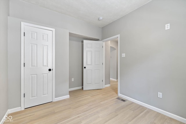 unfurnished bedroom with baseboards, visible vents, and light wood-type flooring