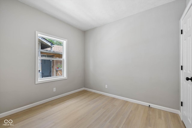 unfurnished room with baseboards and light wood-style flooring