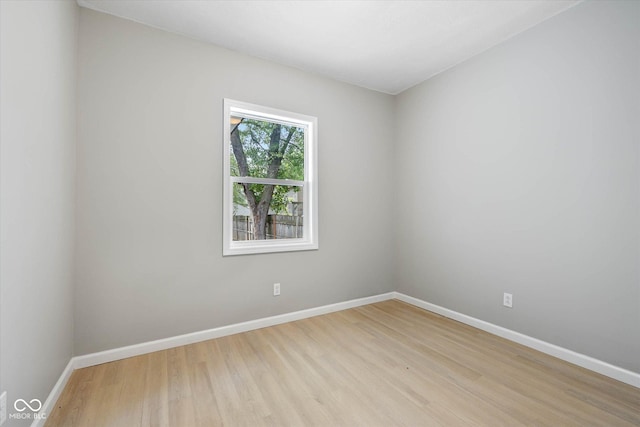 empty room featuring light wood-type flooring and baseboards