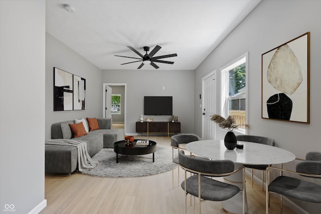 living area featuring a wealth of natural light, baseboards, a ceiling fan, and wood finished floors