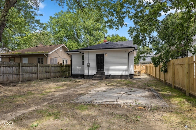 back of property featuring entry steps and a fenced backyard