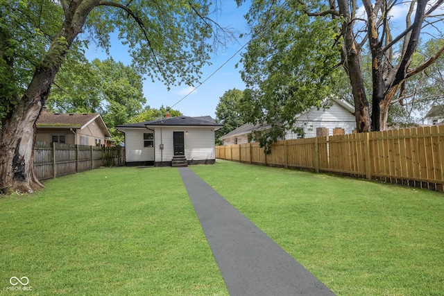 view of yard featuring entry steps and a fenced backyard