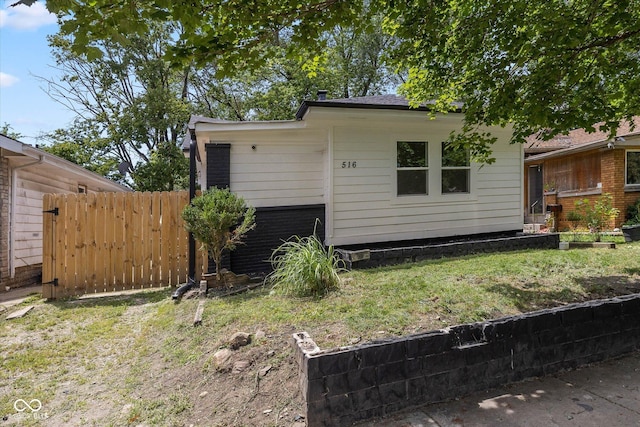 exterior space with brick siding, a yard, and fence