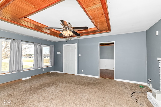 unfurnished living room with visible vents, a raised ceiling, carpet, baseboards, and ceiling fan