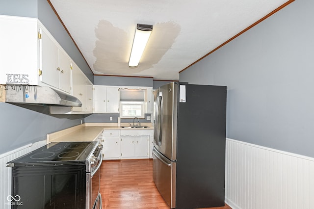 kitchen featuring a wainscoted wall, a sink, under cabinet range hood, white cabinetry, and stainless steel appliances