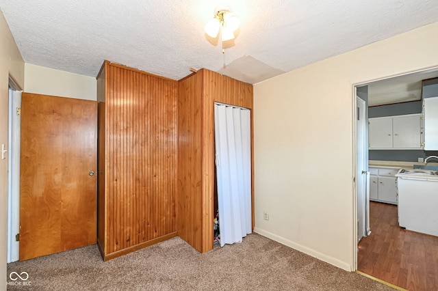 unfurnished bedroom with carpet floors, a textured ceiling, and a sink