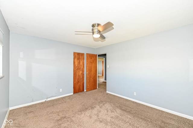 spare room with a ceiling fan, carpet, and baseboards