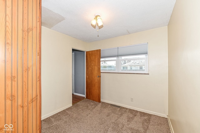 unfurnished bedroom featuring a closet, baseboards, carpet floors, and a textured ceiling