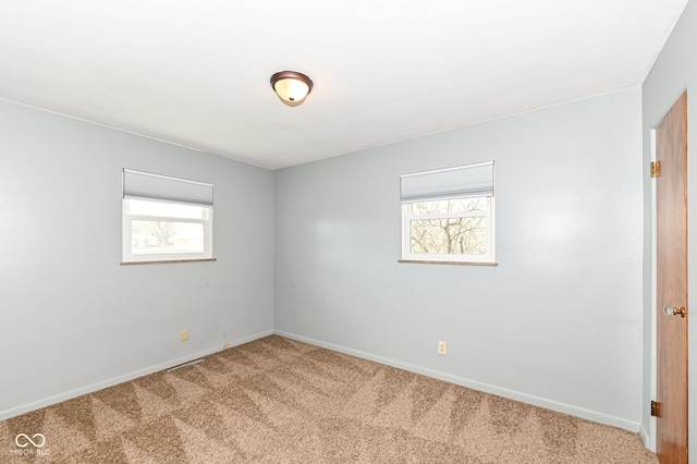 spare room with baseboards and carpet floors