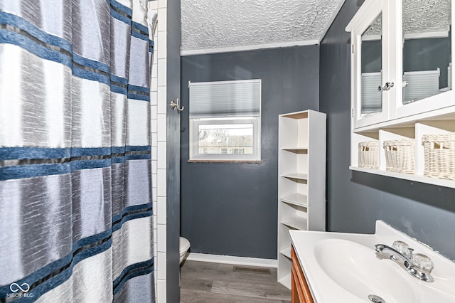 full bath with vanity, wood finished floors, a textured ceiling, curtained shower, and toilet