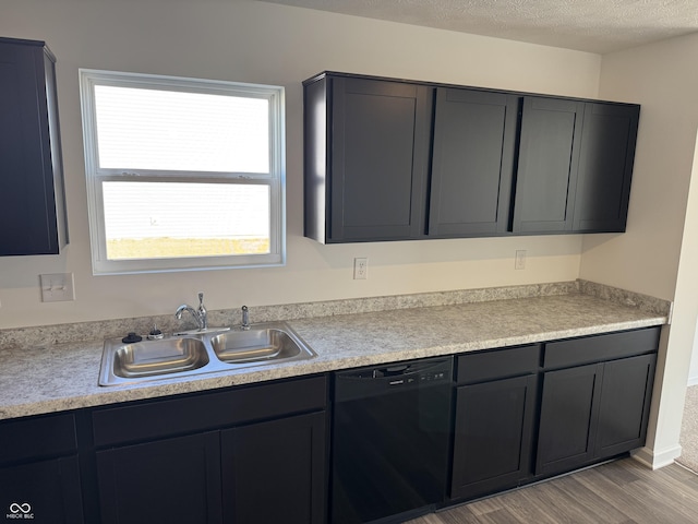 kitchen featuring dishwasher, light countertops, a textured ceiling, and a sink