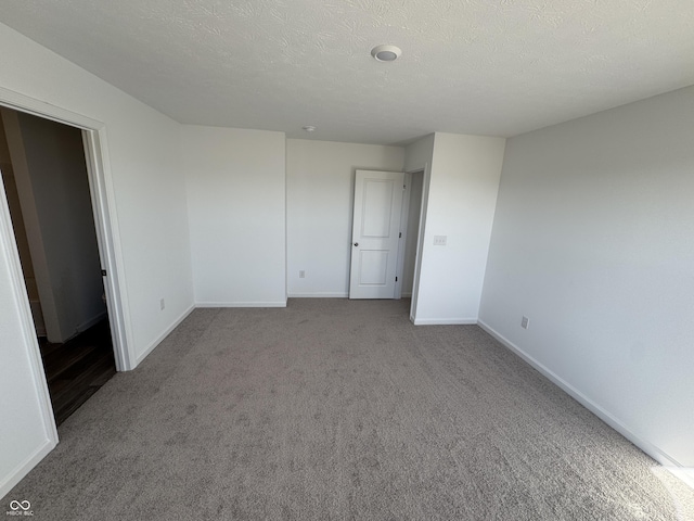 unfurnished bedroom featuring carpet flooring, baseboards, and a textured ceiling