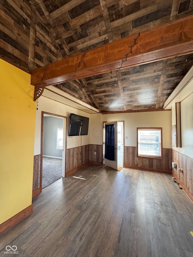 interior space featuring vaulted ceiling with beams, wood finished floors, and wainscoting