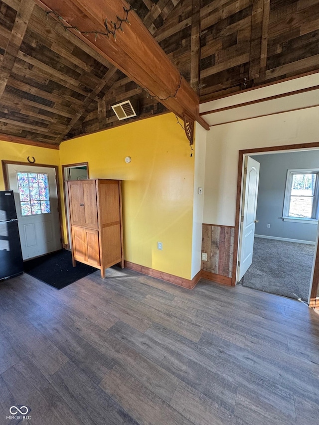 empty room with baseboards, visible vents, high vaulted ceiling, dark wood-style flooring, and wooden ceiling