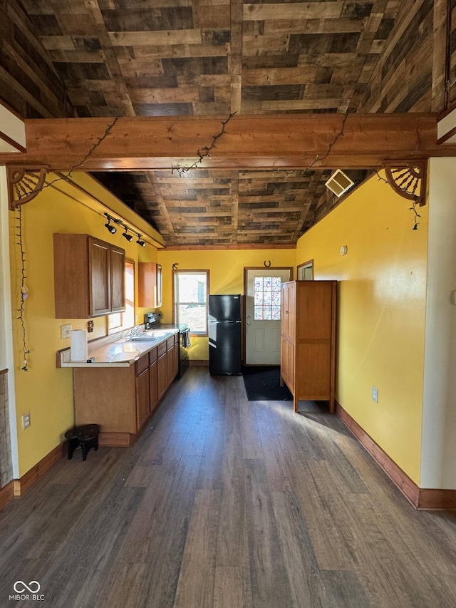 kitchen with lofted ceiling with beams, light countertops, freestanding refrigerator, and dark wood-type flooring