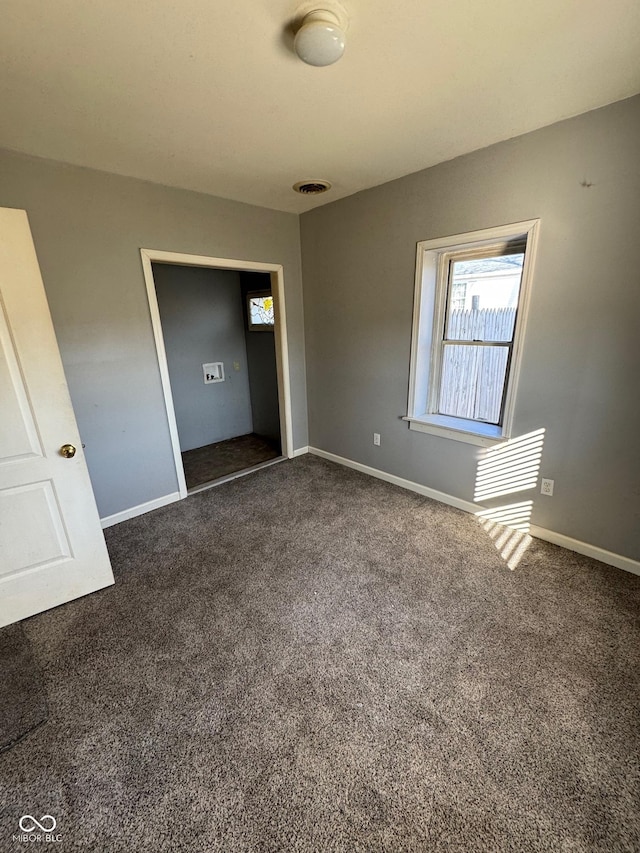 unfurnished room featuring carpet flooring, baseboards, and visible vents