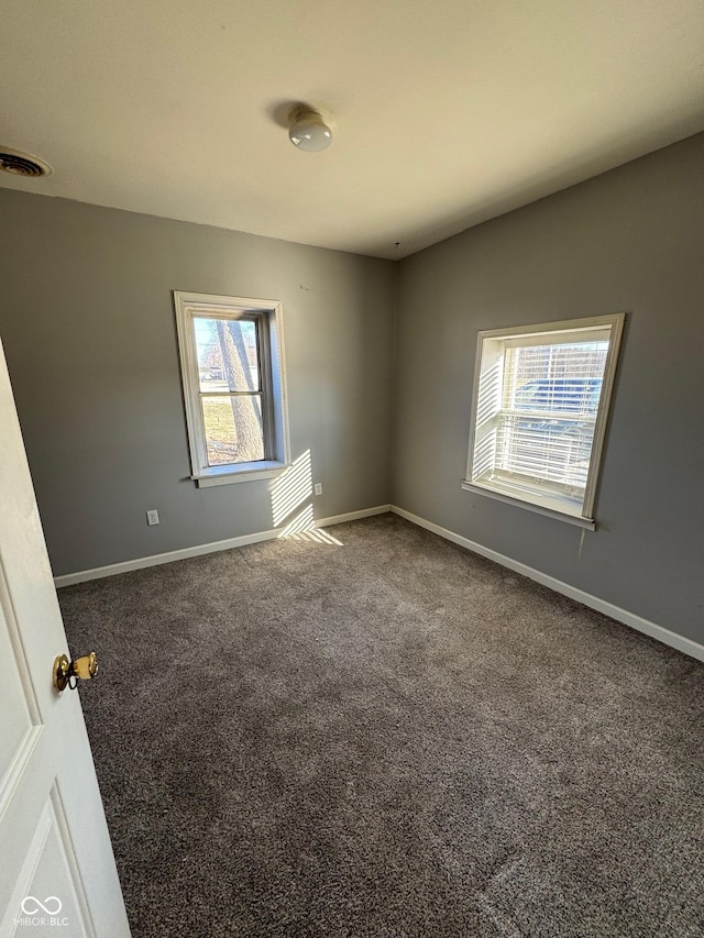 empty room with visible vents, baseboards, and carpet