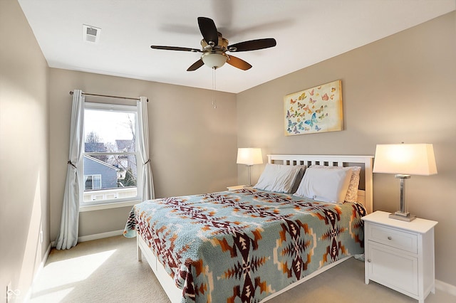 bedroom with a ceiling fan, baseboards, visible vents, and light carpet