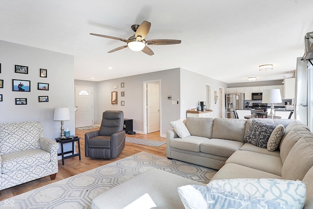 living room with recessed lighting, light wood-type flooring, and a ceiling fan