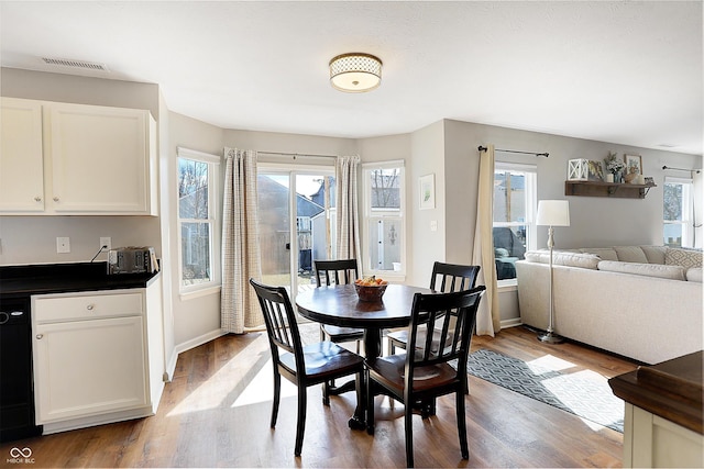 dining room featuring visible vents, baseboards, and wood finished floors