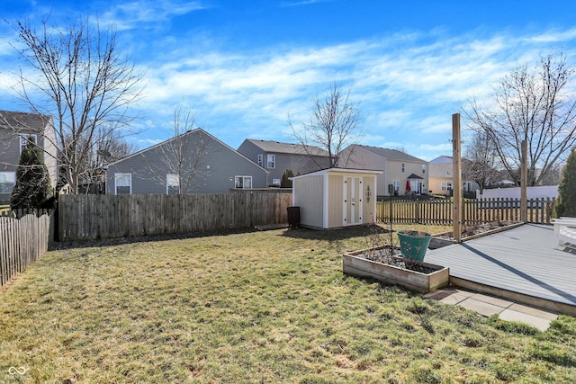 view of yard with an outbuilding, a fenced backyard, a residential view, and a shed