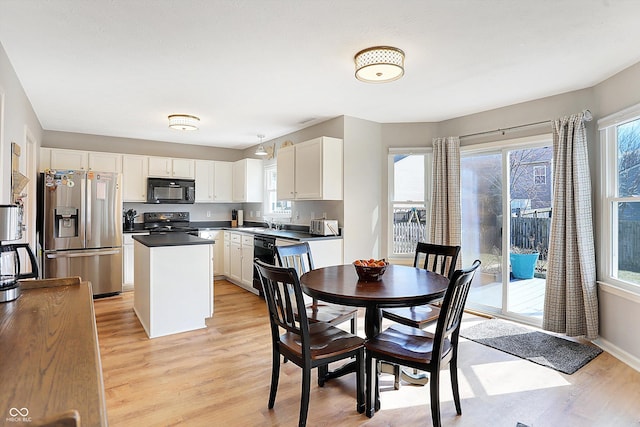 dining space with baseboards, a healthy amount of sunlight, and light wood finished floors