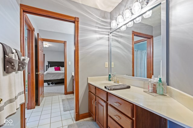 ensuite bathroom with vanity, ensuite bathroom, baseboards, and tile patterned flooring