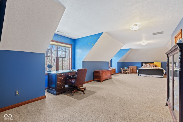 office area with vaulted ceiling, visible vents, carpet floors, and a textured ceiling