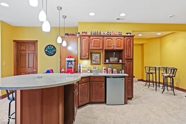 kitchen with visible vents, light carpet, a peninsula, fridge, and a sink