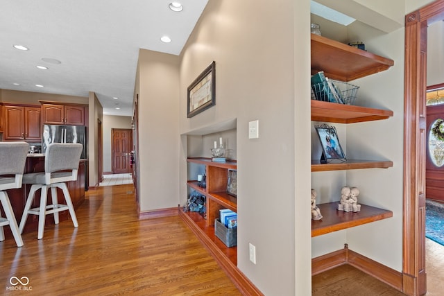 corridor with recessed lighting, baseboards, and light wood finished floors