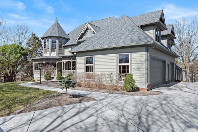 view of front facade with covered porch, driveway, and a shingled roof