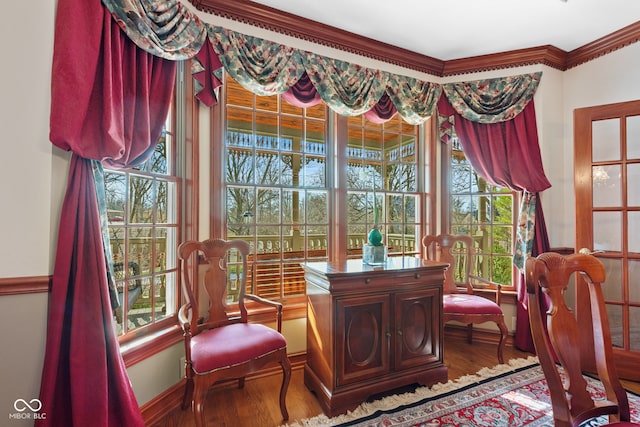 sitting room featuring baseboards, wood finished floors, and ornamental molding