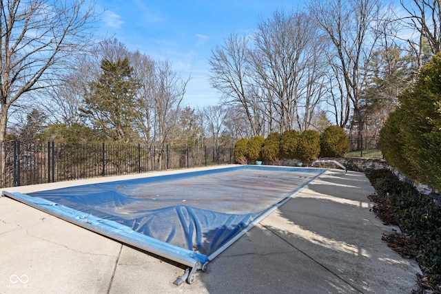 view of swimming pool featuring fence
