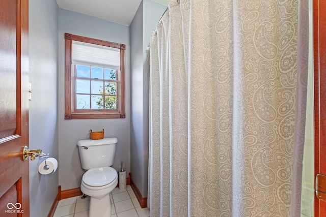 bathroom with tile patterned flooring, toilet, and baseboards