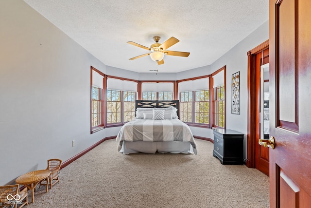 bedroom with baseboards, light colored carpet, ceiling fan, and a textured ceiling