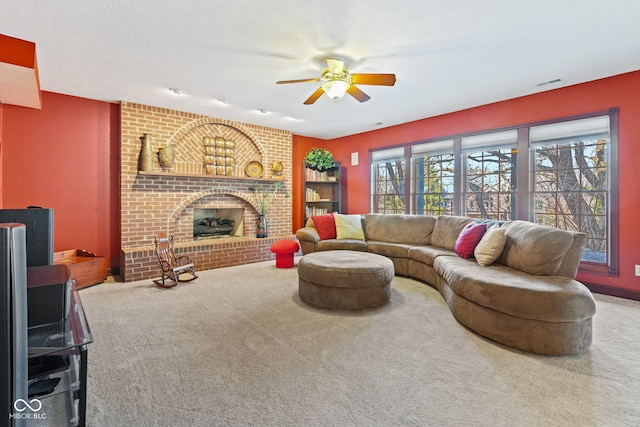 living area featuring visible vents, a fireplace, a ceiling fan, and carpet floors