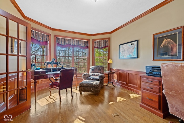 home office featuring a wealth of natural light, wainscoting, wood finished floors, and ornamental molding