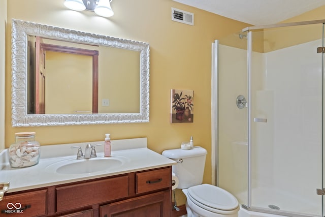 bathroom with vanity, a shower stall, toilet, and visible vents