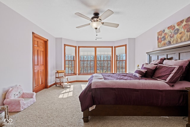carpeted bedroom featuring baseboards and ceiling fan