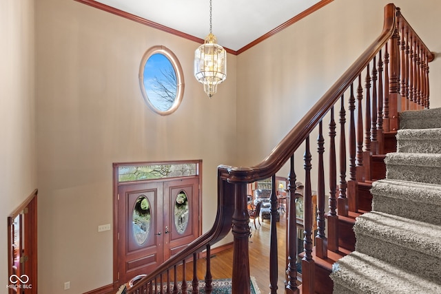 foyer with a chandelier, stairway, a high ceiling, and wood finished floors