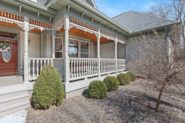 view of side of home with covered porch and roof with shingles