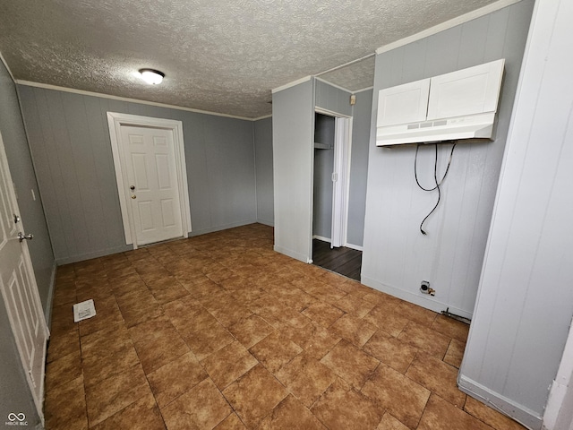 clothes washing area with a textured ceiling and ornamental molding