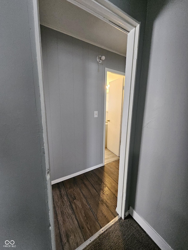 hallway featuring wood finished floors and baseboards