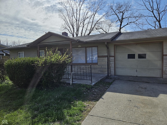 view of front of property featuring stone siding, concrete driveway, and a garage