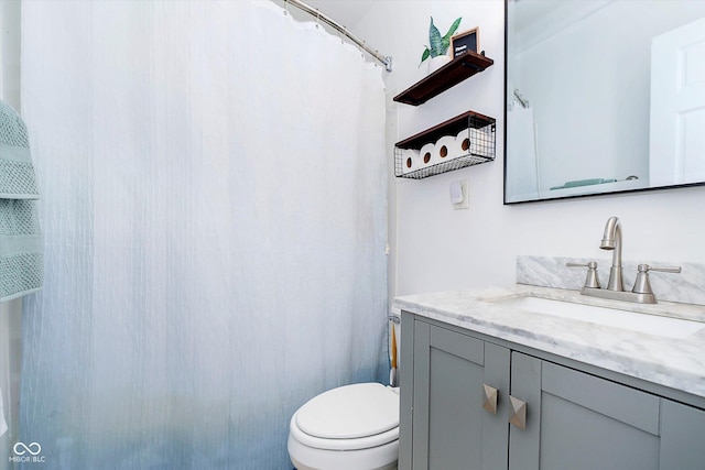 bathroom featuring a shower with curtain, toilet, and vanity