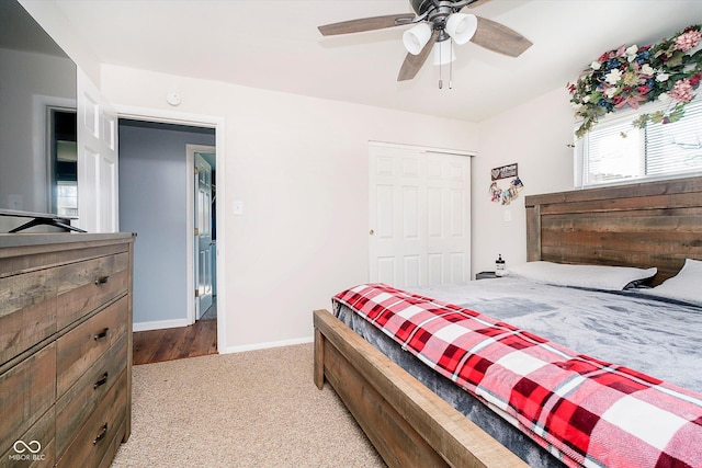 carpeted bedroom with a closet, baseboards, and ceiling fan