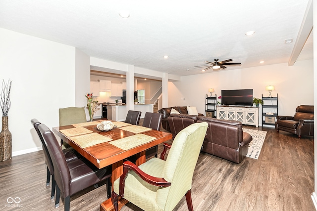 dining space featuring wood finished floors, baseboards, recessed lighting, ceiling fan, and stairs