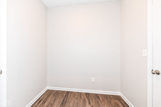 unfurnished room with baseboards and dark wood finished floors