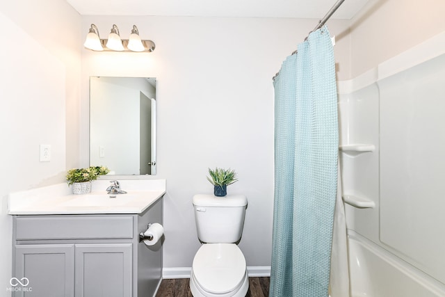 bathroom featuring vanity, toilet, wood finished floors, and baseboards