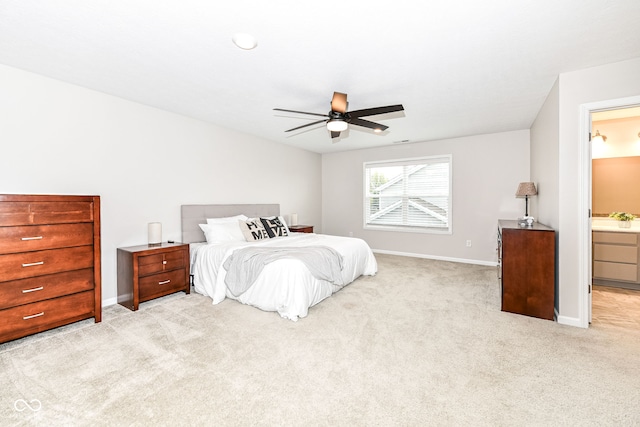 bedroom with a ceiling fan, light colored carpet, baseboards, and a sink